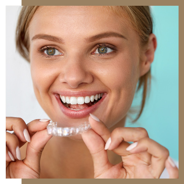 smiling woman with beautiful smile using teeth whitening tray