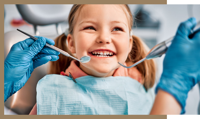 young girl smiling at dentist during childs checkup
